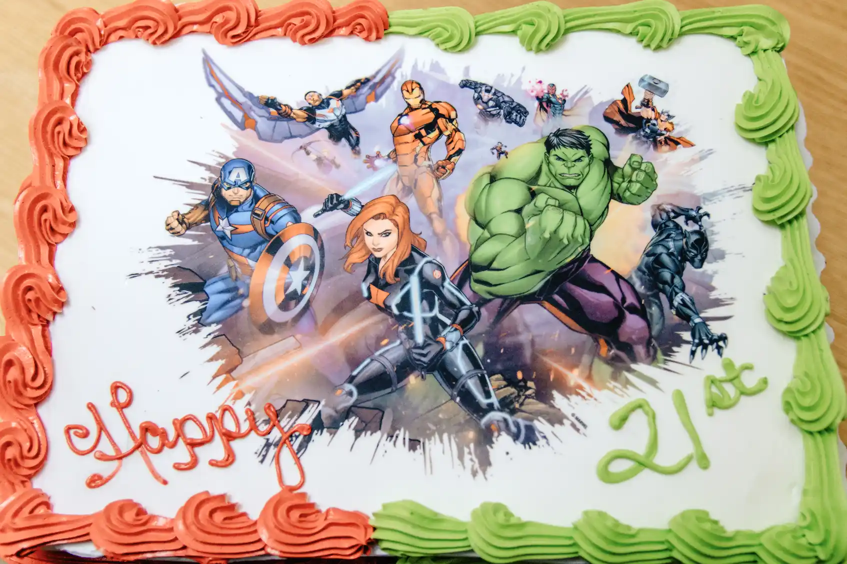 a cake with a picture of superheros on it that reads happy 21st