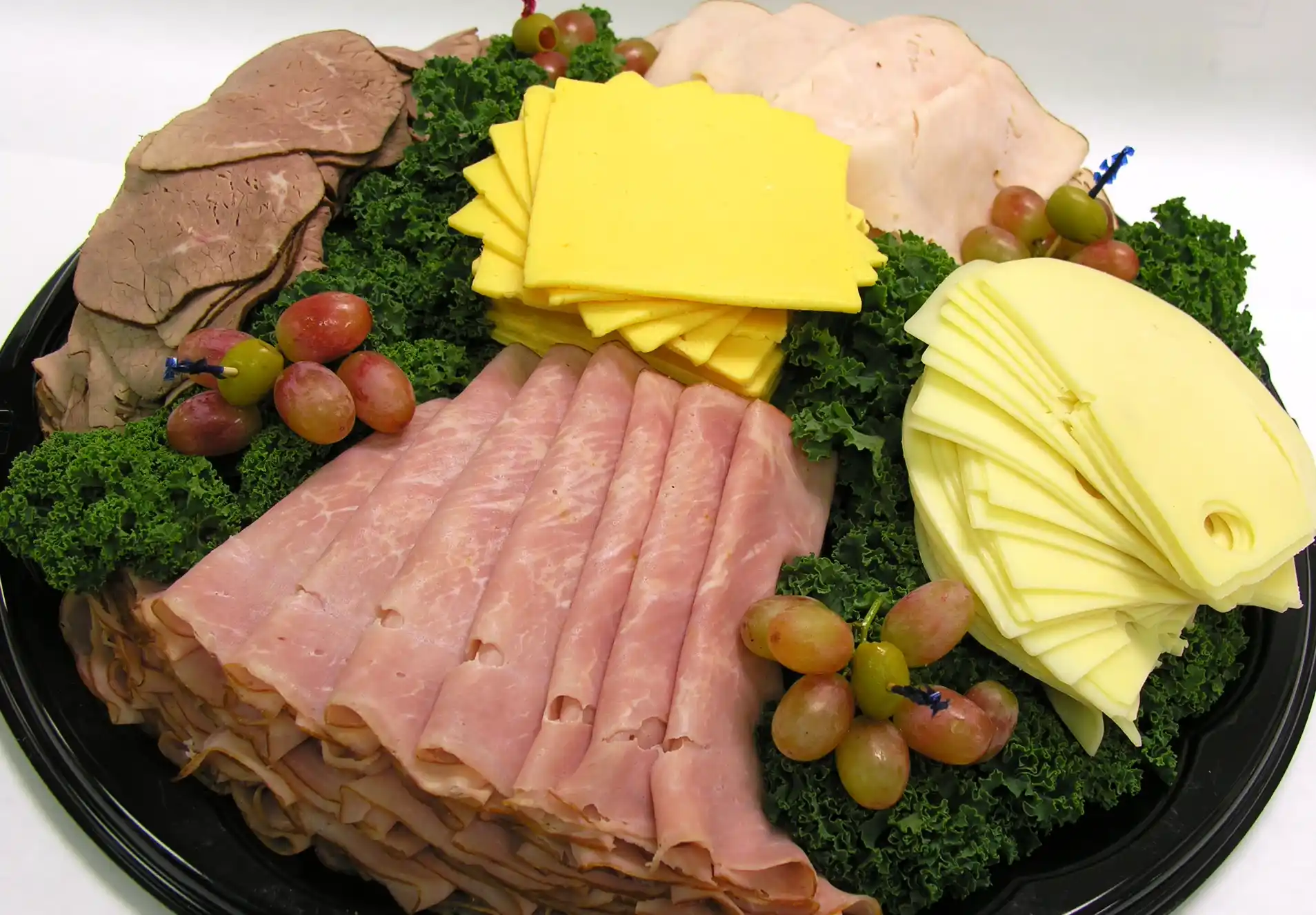 a variety of meats and cheeses sliced for sandwiches